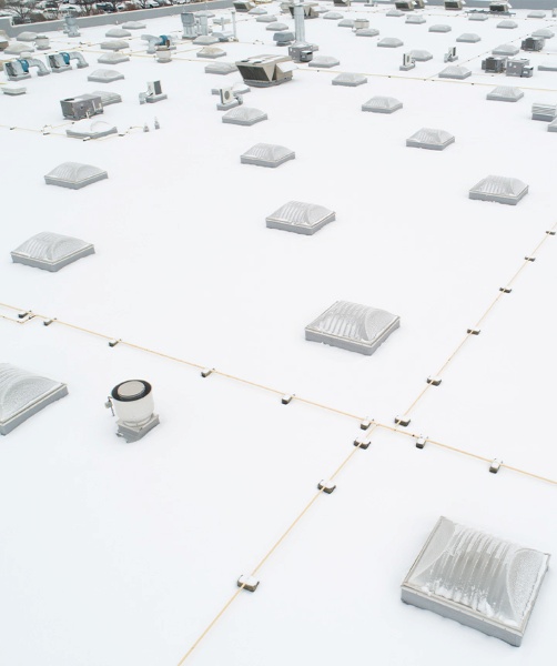 Aerial view of white commercial building with a flat rooftop